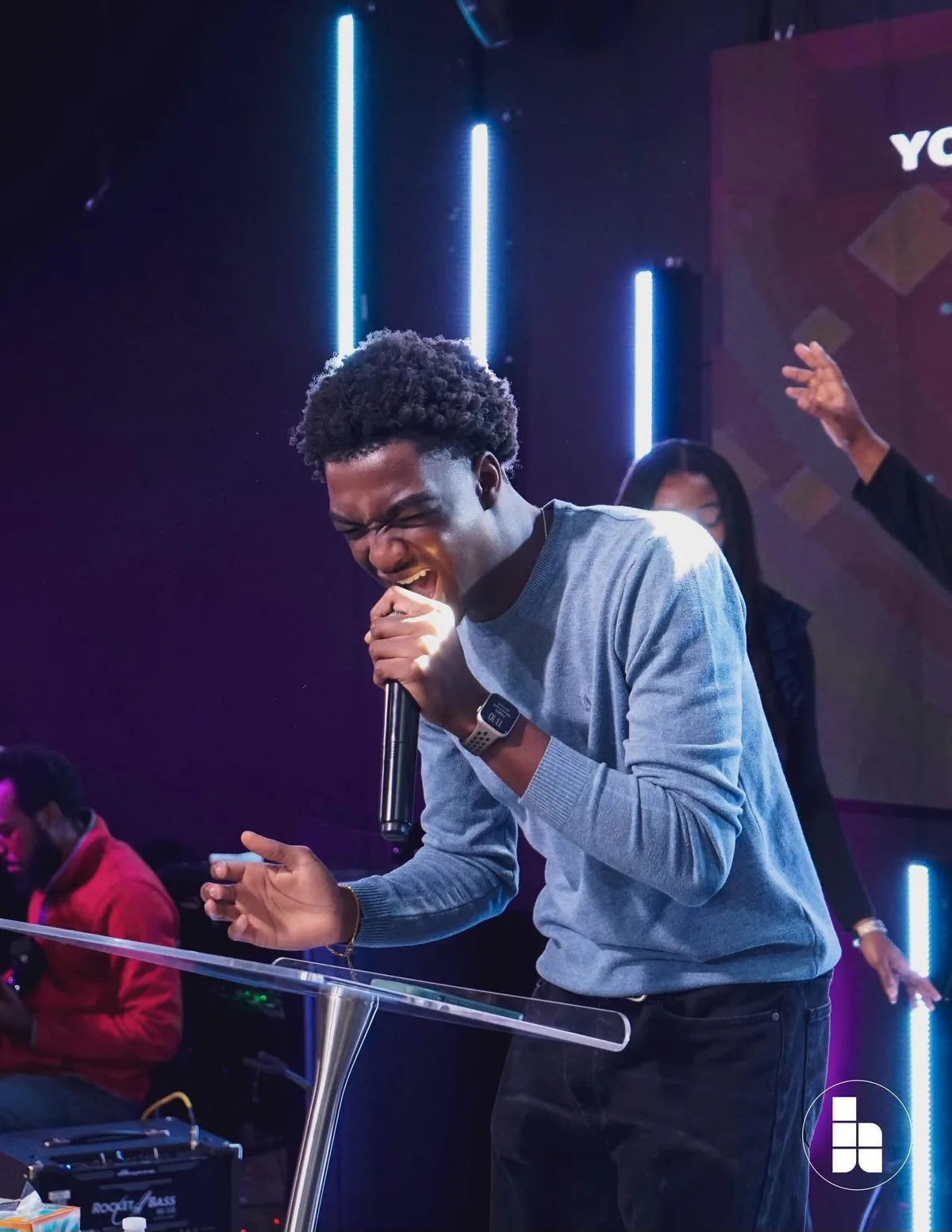 A young worship leader singing during a Sunday service