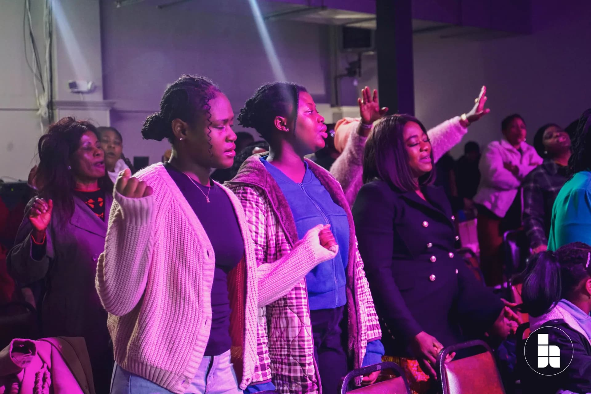The congregation with hands raised during a service