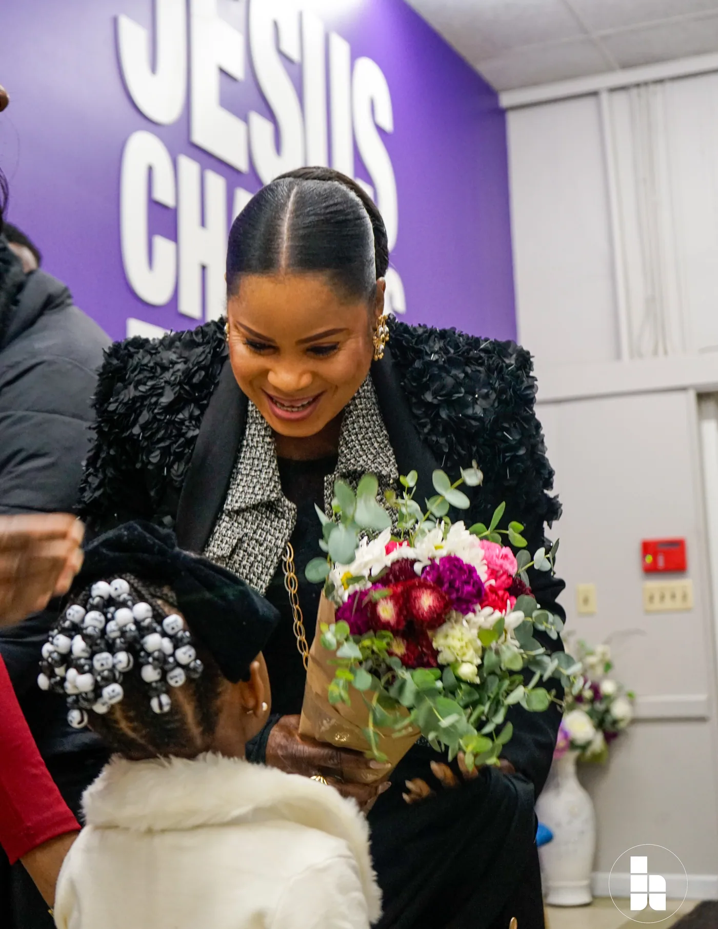 A member of the welcome team greeting a guest with flowers