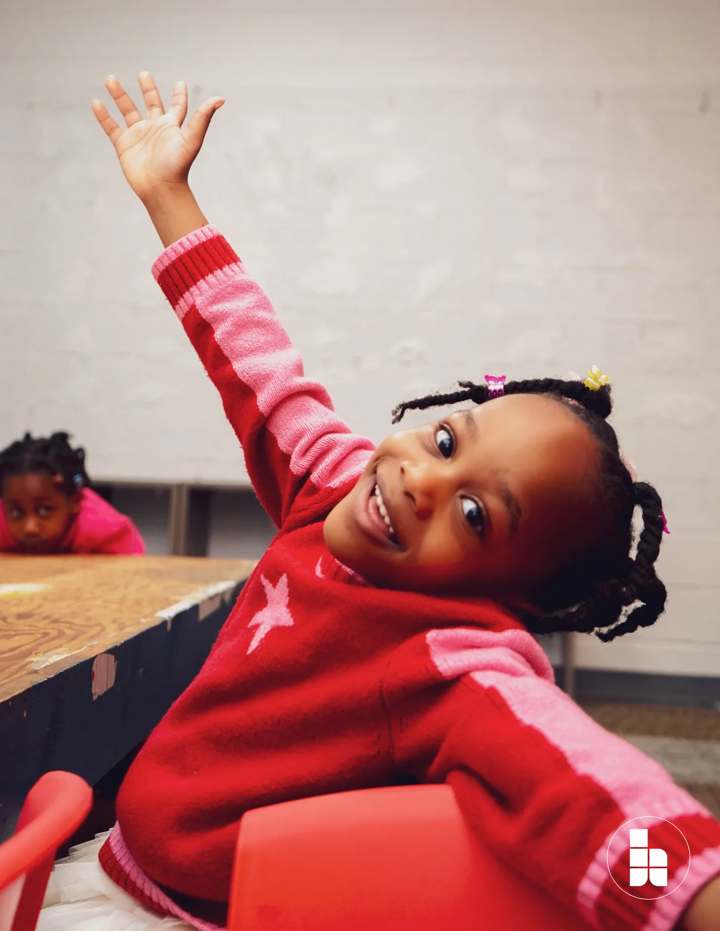 A child raising a hand to answer a question in Jubilee Kids