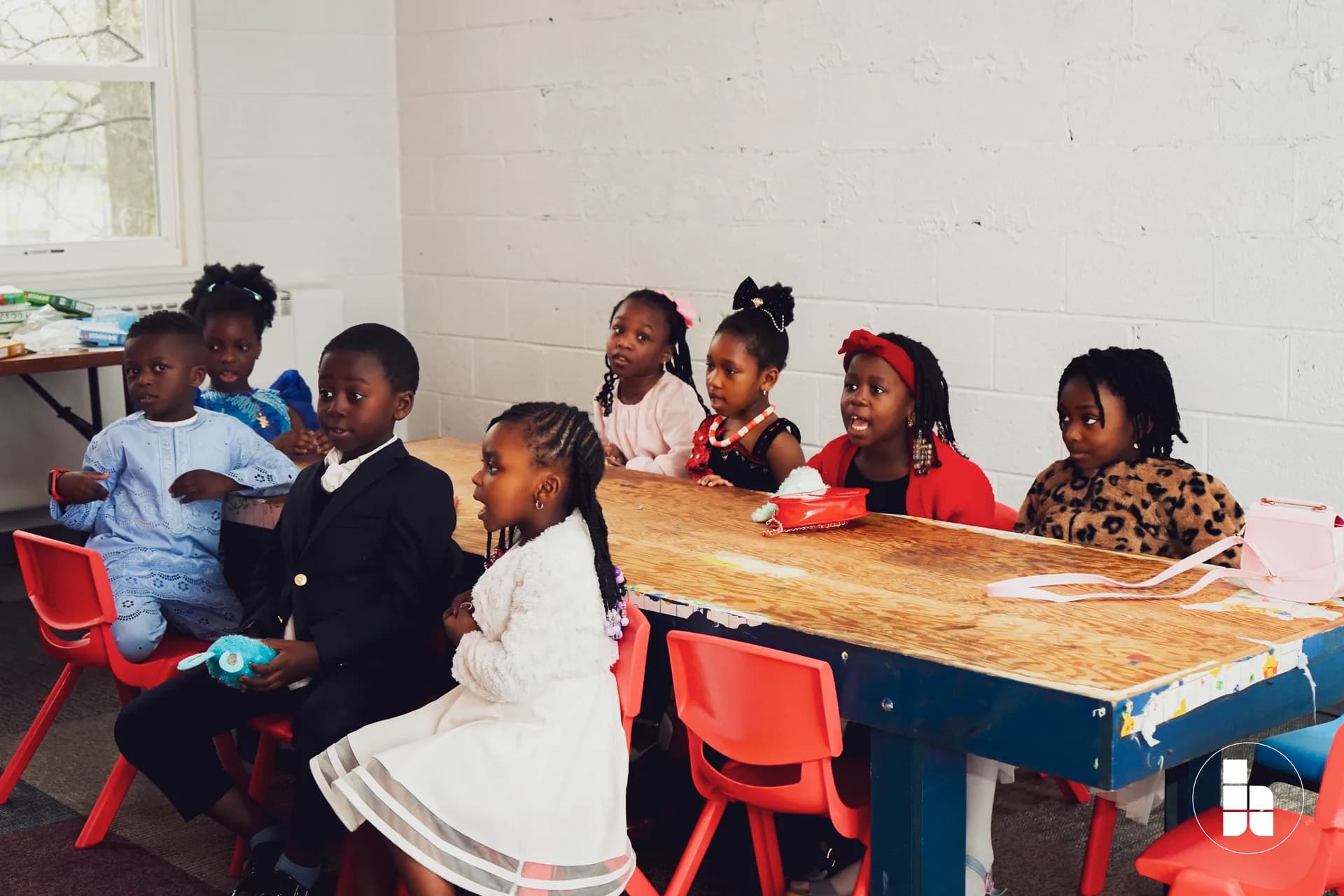 Children gathered around a table during Jubilee Kids